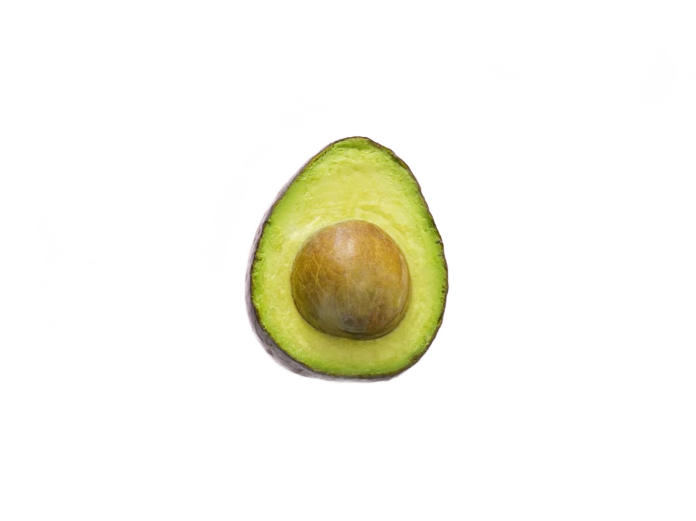 An avocado half with its stone on a pink background, background removed