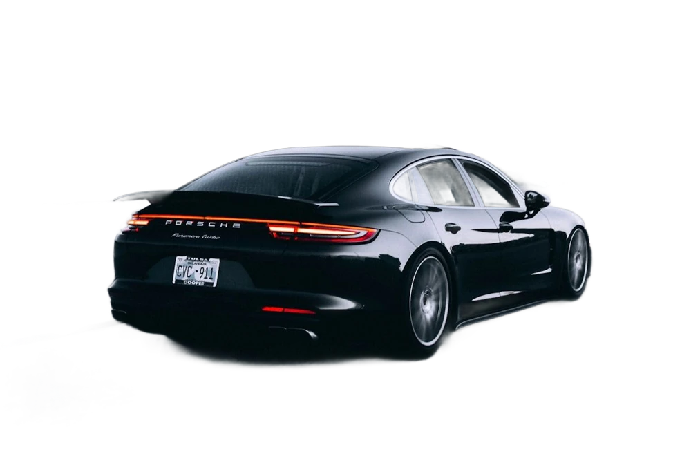 A dark sports car on a road, background removed
