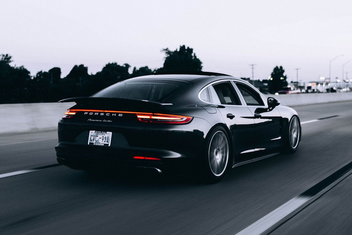 A dark sports car on a road, original photo