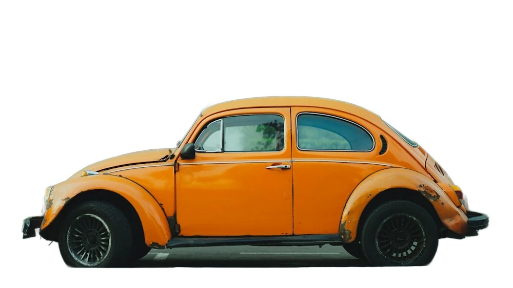 An orange vintage Beetle parked in front of a building, background removed