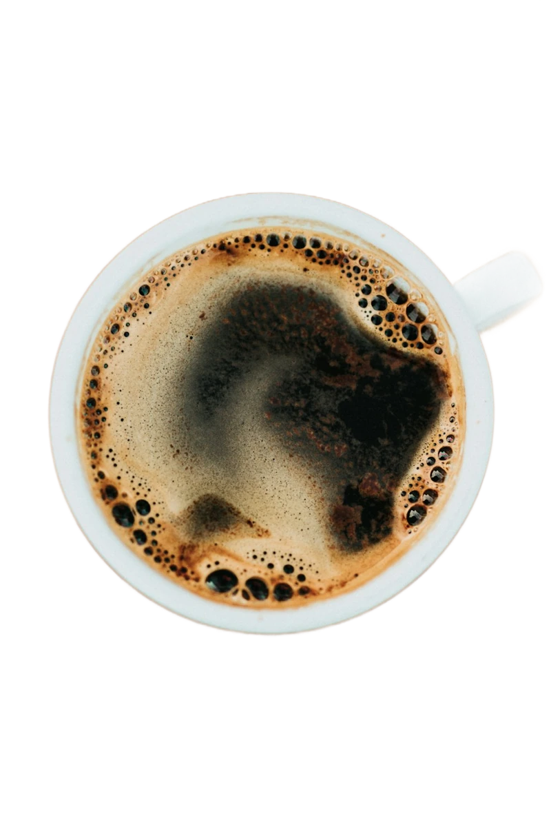 An overhead view of a cup of black coffee on a wooden table, background removed