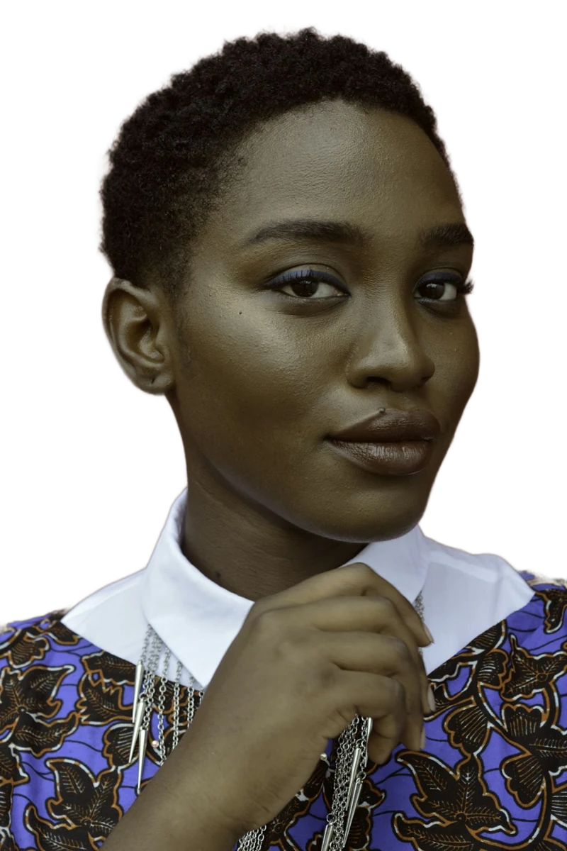 A woman with short natural hair and a patterned top resting her hand under her chin, background removed