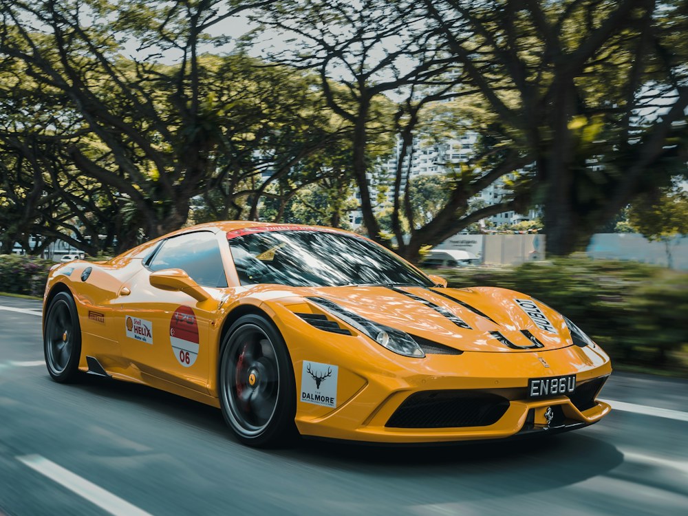 An orange sports car on a tree-lined street, original photo